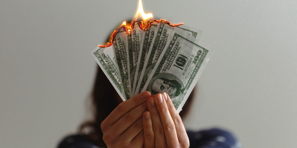 Pessoa queimando dinheiro.